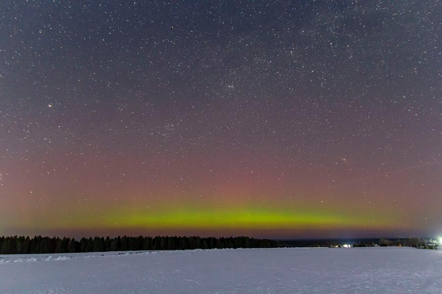 Северное сияние (aurora borealis) и Млечный путь на звёздном небе ночью в конце марта в Кировской области